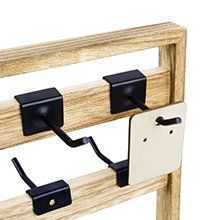Upper corner detail of wooden jewelry display rack with metal hooks